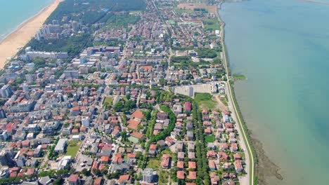 aerial tilt revealing lignano sabbiadoro town located on a narrow strip of land surrounded by water