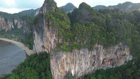 Acantilado-De-Piedra-Caliza-De-La-Selva-Tropical-En-Krabi,-Tailandia---Retroceso-Aéreo---Playa-Railay-Y-Tonsai