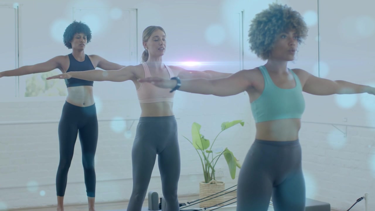 Three Pilates women standing on reformers, following center breath cue, syncing pulses for posture