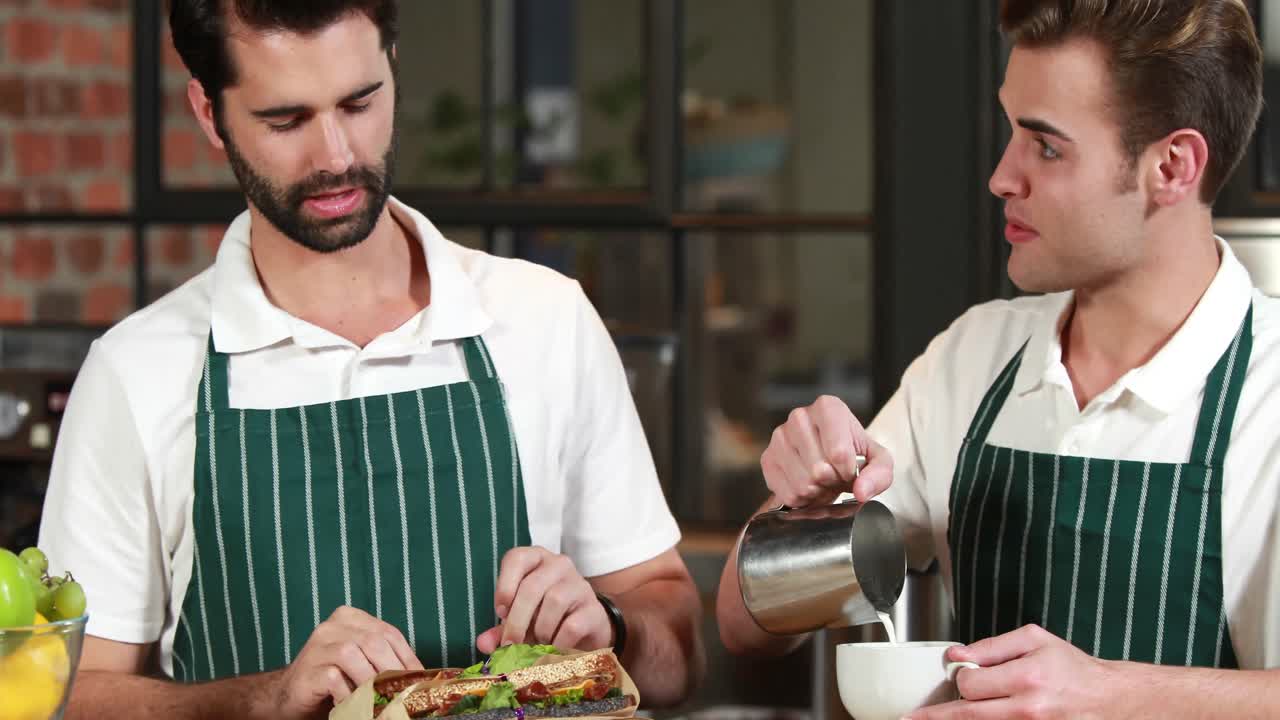 el camarero sonriente y el barista discutiendo juntos