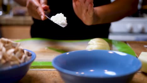 tossing diced onions in a bowl in preparation for a homemade dish in slow motion