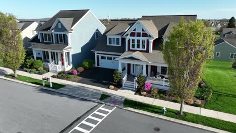 quaint houses and homes in american suburb with blooming plants in front yard