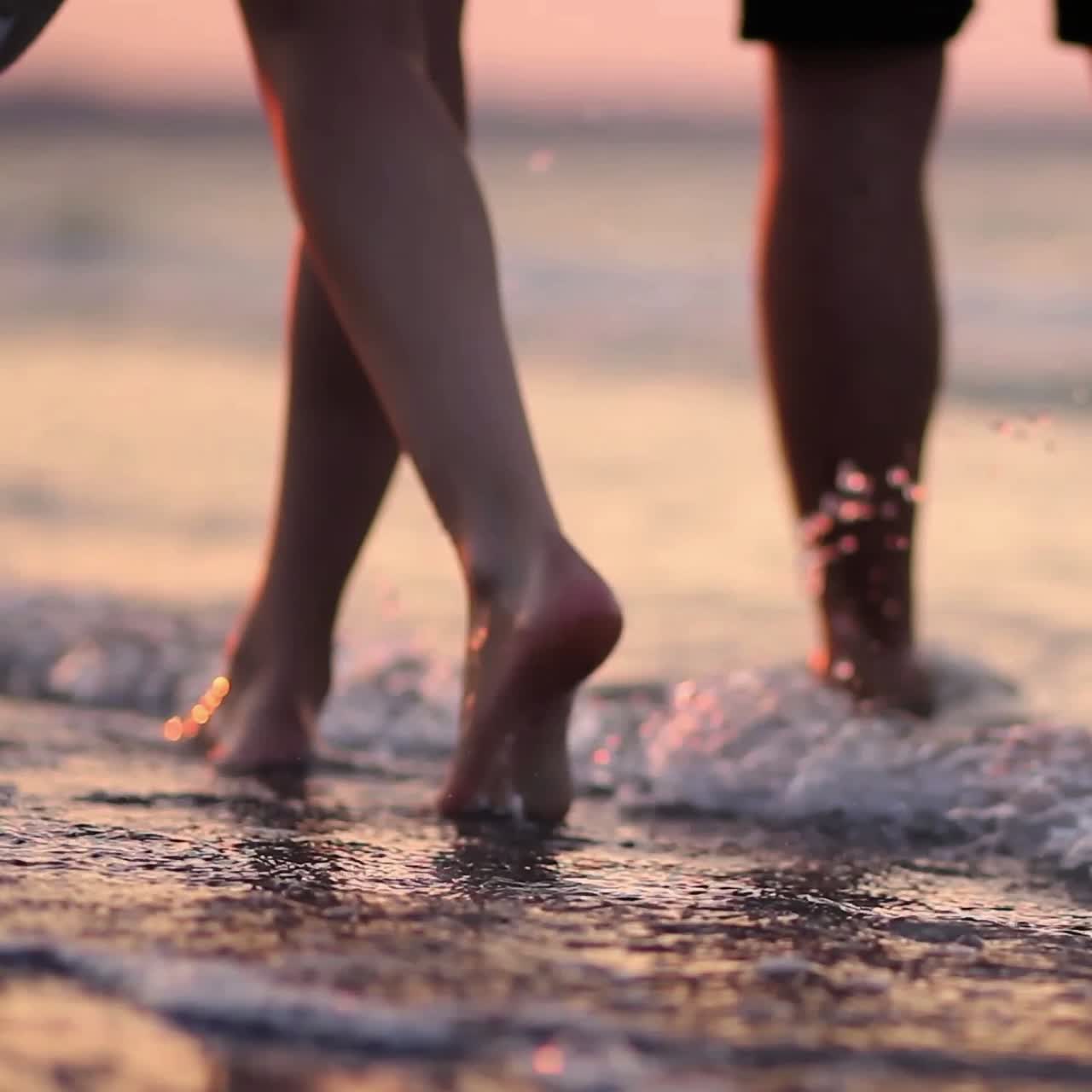 Vacations On The Idyllic Beach. Legs of the young man and woman during amazing sunset