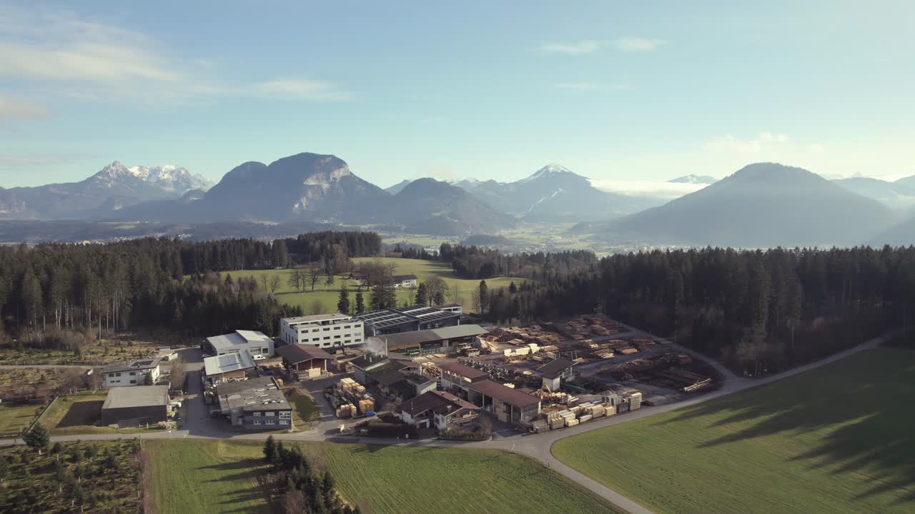 drone aéreo de la hermosa cordillera alpina en la distancia con pintorescos campos de hierba y bosques