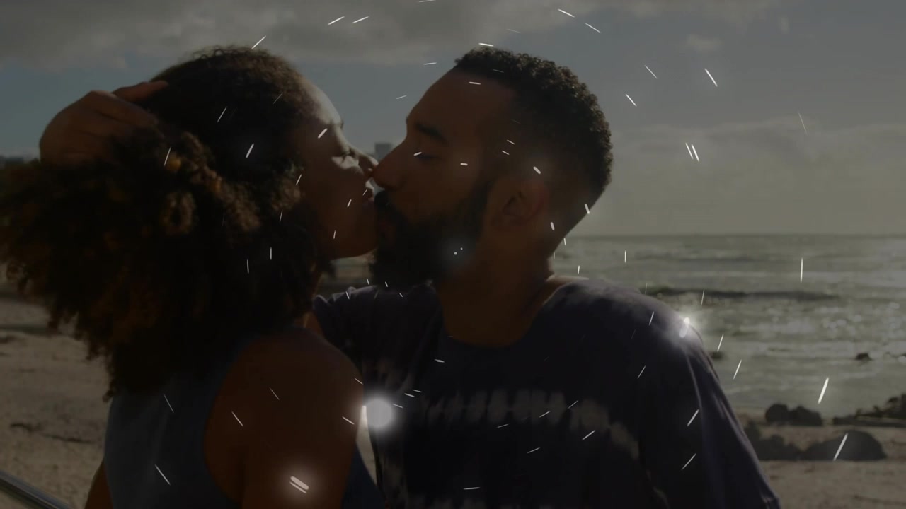 Homme tendant la main, femme se penchant pour embrasser sur la plage avec des anneaux lumineux se formant autour des visages, pour des publicités