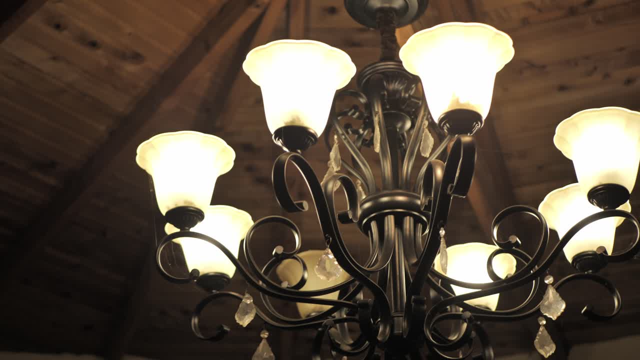 Old Bronze Chandelier With Bell-Shaped White Scavo Glass. Low Angle Shot