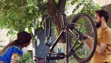 pareja deportiva reparando bicicletas al aire libre