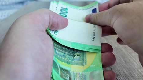 a man holds and counts euro banknotes