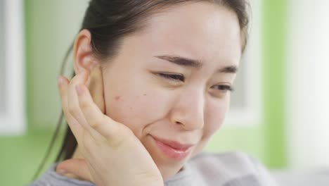 심각하고 장기적인 귀 통증을 가진 아시아 젊은 여성.
