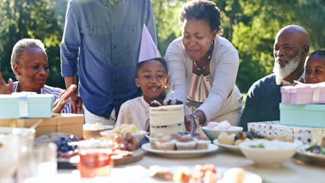 child, happy birthday and blow candles in outdoor
