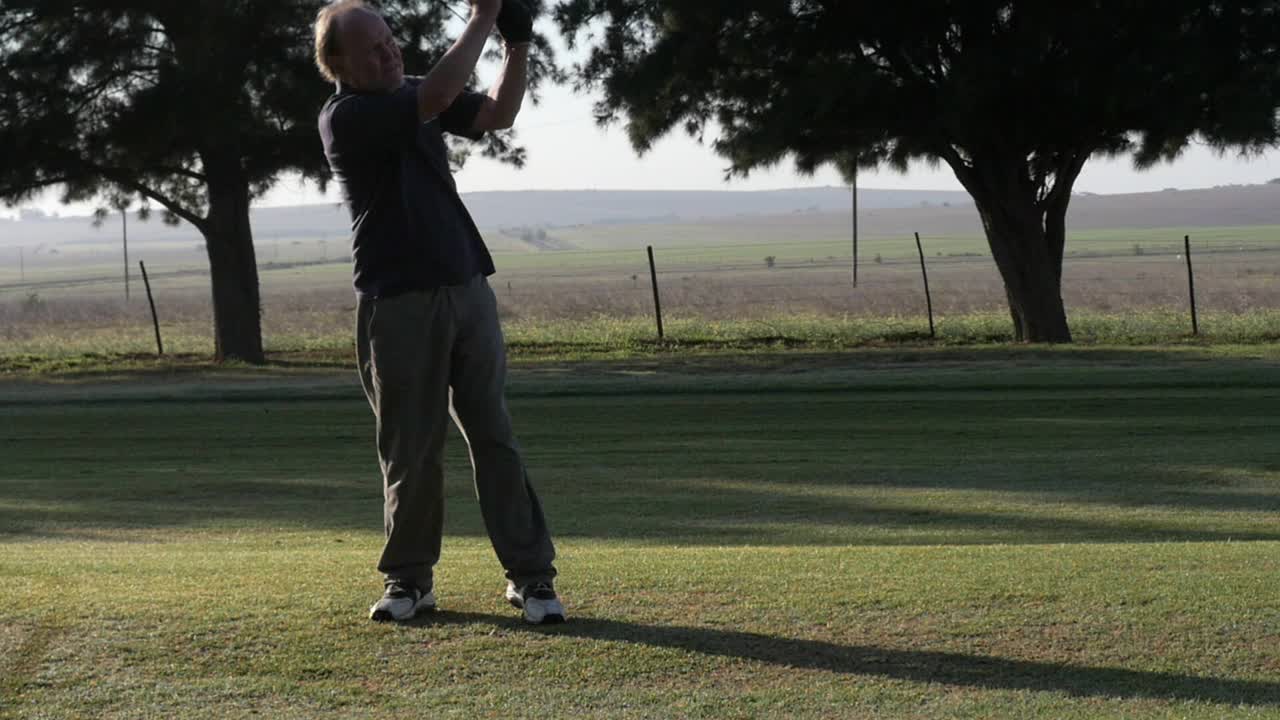 골퍼는 남아프리카 골프 코스에서 페어웨이에서 나무를 흔들고, 느린 움직임과 넓은