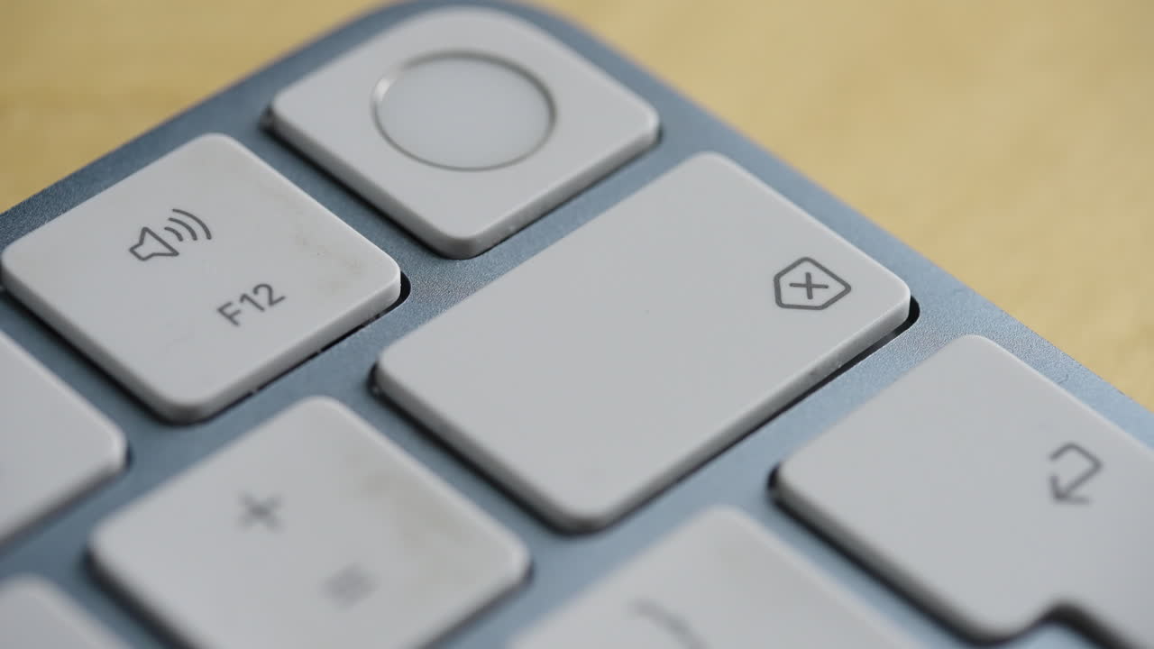 Close up shot of a person repeatedly pressing the backspace button on a sleek computer keyboard. Ideal for concepts of editing, correcting mistakes, and data deletion