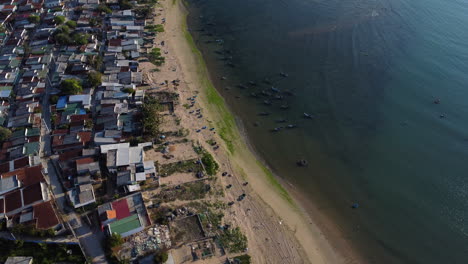 Antena-De-Arriba-Hacia-Abajo-De-La-Ciudad-De-Pescadores-Con-Playa-De-Arena-Y-Botes-De-Canasta-Tradicionales-Flotantes-En-El-Océano---Vietnam,-Asia