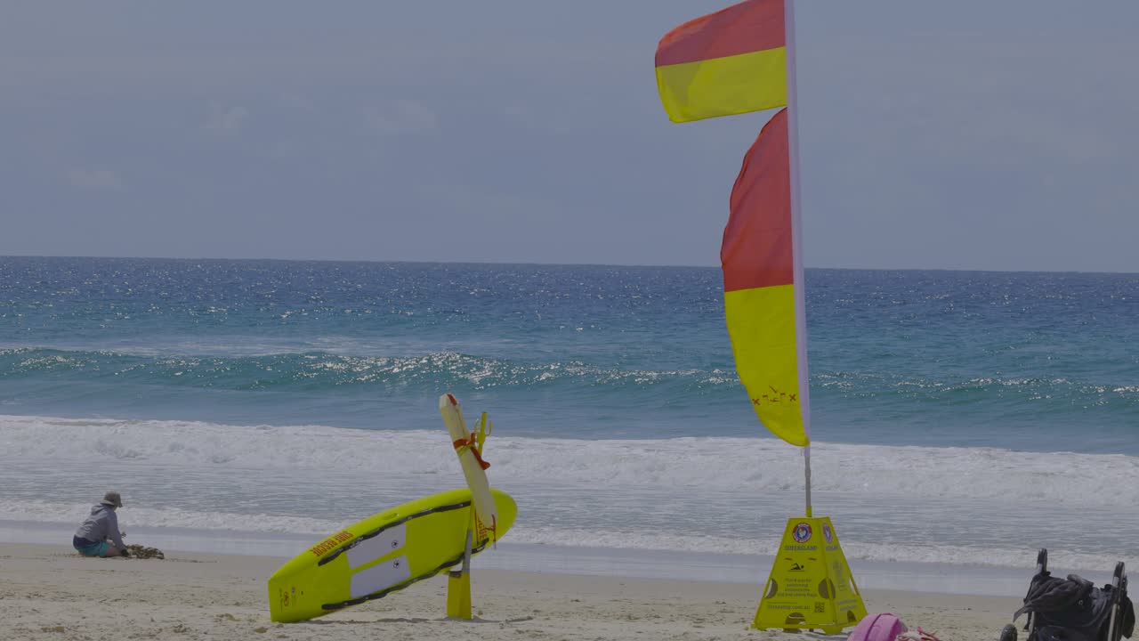 bandera de salvavidas y persona en la playa de currumbin