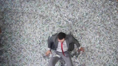 portrait of a male businessman looks at the camera and throws banknotes top view