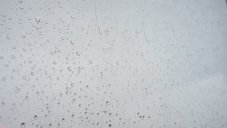 Un-Vídeo-En-Cámara-Lenta-De-Fuertes-Gotas-De-Lluvia-Cayendo-Sobre-El-Cristal-De-Una-Ventana