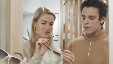 couple trying on glasses in an optician's