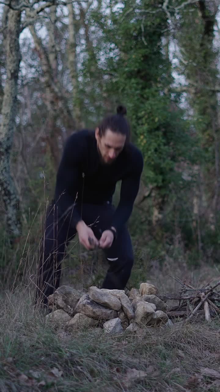 Man building a campfire in the forest
