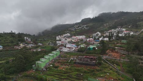 top-down shot of a hilltop hotel and its organized parking area amidst greenery