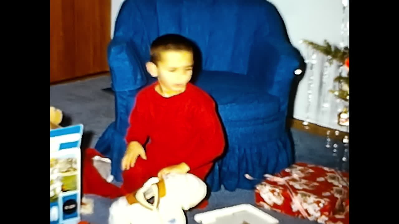 Young Boy in Red Pajamas Sitting on Blue Chair. CIRCA USA - 1970s: A young boy dressed in red pajamas is seated on a blue chair.