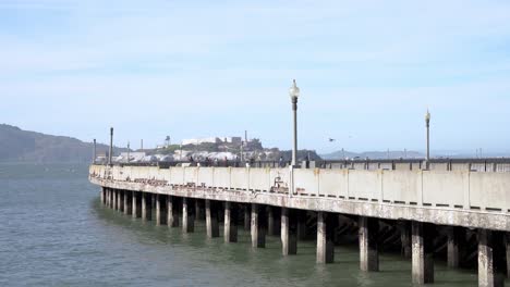 gente caminando por el muelle y la isla de alcatraz al fondo