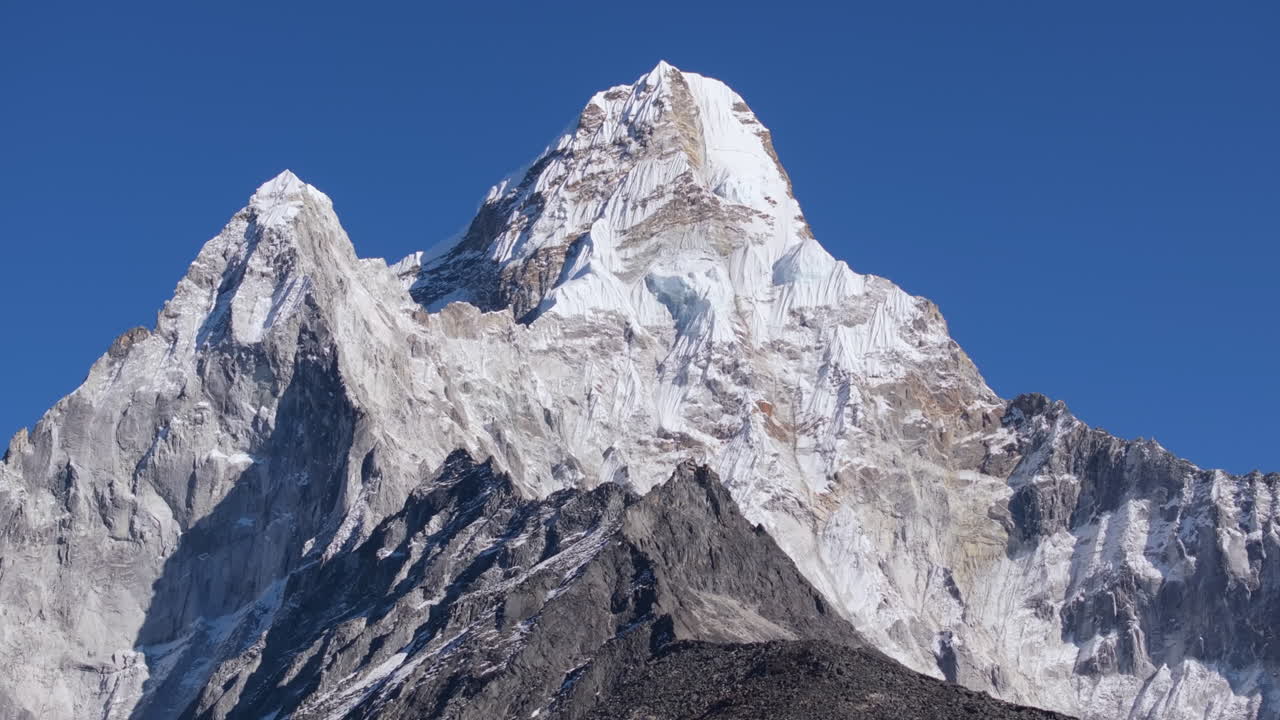 Ripresa aerea orbitante con drone dell'Ama Dablam nella regione dell'Everest in Nepal, che crea un profondo effetto di parallasse con le cime himalayane circostanti. Incredibile paesaggio montano innevato catturato dall'alto