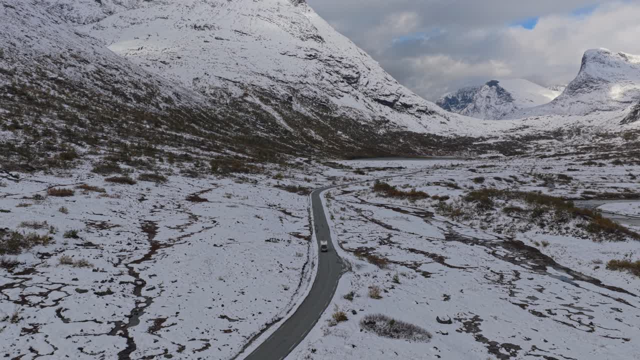 Top-down view of car winding through frozen Nordic landscape