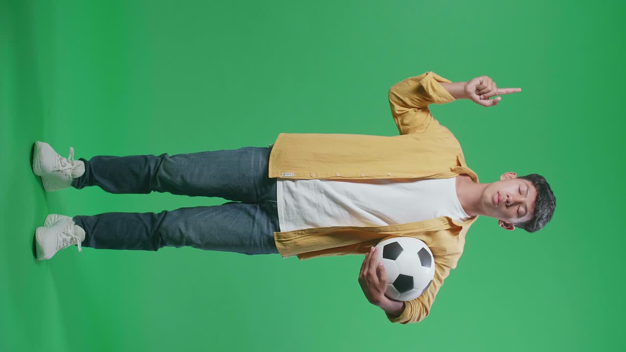 Young Man Holding a Soccer Ball on Green Screen