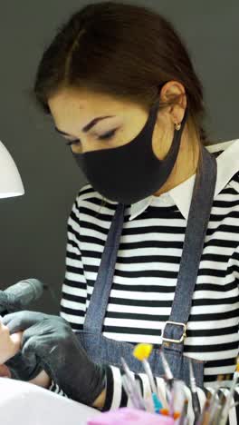 woman in a nail salon receiving a manicur
