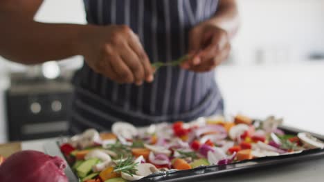 sección media de mujer afroamericana preparando la cena en la cocina