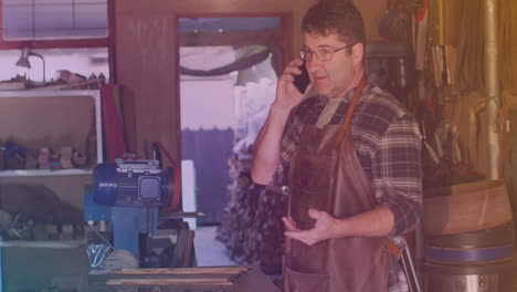 animación de un trabajador caucásico hablando con un teléfono inteligente en un taller