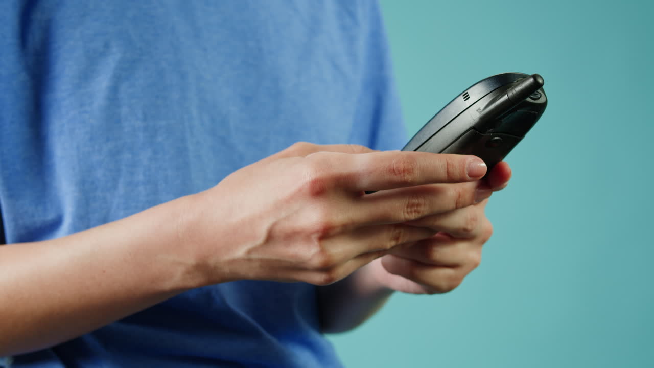 persona con un teléfono celular de época