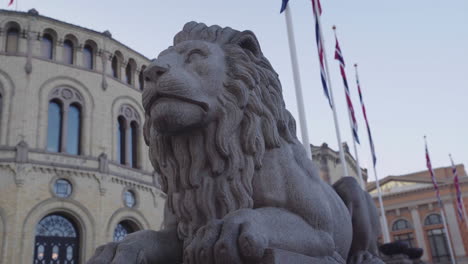 guarding lion statue in front of the norwegian parlament building