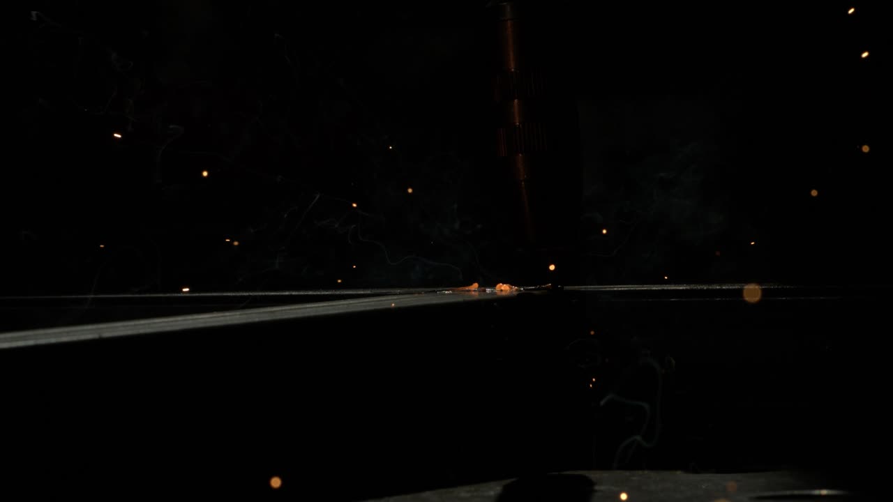 산업적 배경으로 두 개의 모양의 금속 파이프를 함께 용접하기 시작하는 용접기의 근접 촬영