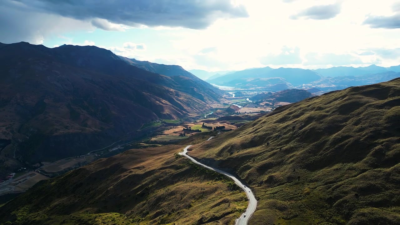 Veduta aerea sul Passo di montagna di Cardrona che porta da Queenstown a Wanaka, Isola del Sud, Nuova Zelanda. Dolly lento all'indietro con drone.