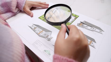 architect at the construction site checks house plan documents with a pencil to check structural design, correctness, and construction strength