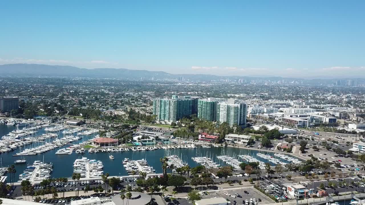 Cove condominiums buildings beside famous marina del Rey in California. Aerial wide shot. Sunny summer day with parking boats and yachts