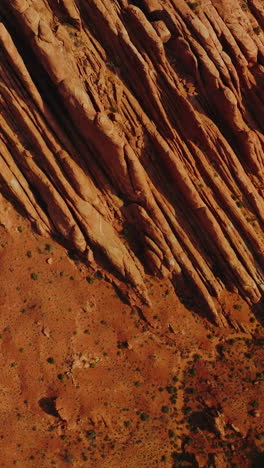 stunning rocks of american canyons on sunny daytime. highway road passing through the dry desert in utah state from top view. vertical video
