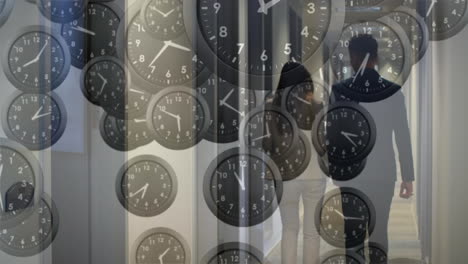 animation of ticking clocks against rear view of businessman and businesswoman walking in office