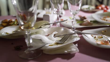 empty plate after eating food. with fork and knife on it. wasted food on festive table after dinner party