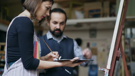 artist and student painting in studio