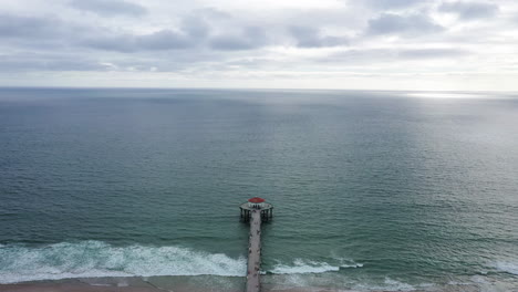 playa de arena y muelle de madera con mirador al final, vista aérea de drones