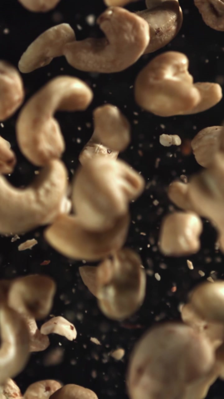 Cashewnøtter fallende i sakte film på svart bakgrunn
