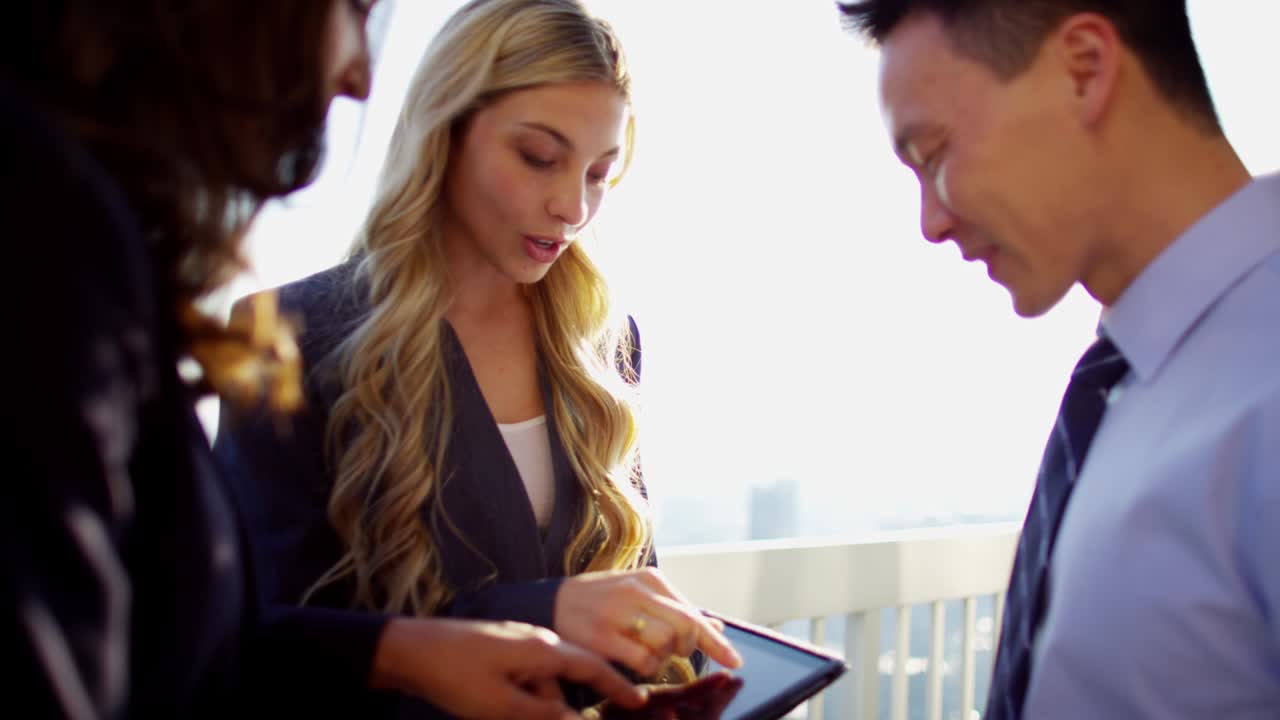 Multi ethnic business people using touchscreen on rooftop