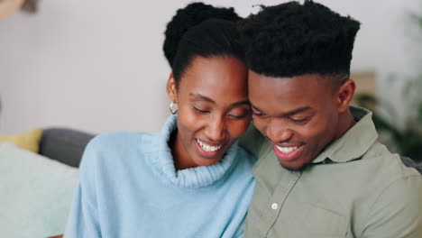 Love,-laugh-and-african-couple-relaxing-on-a-sofa