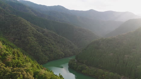 Fluss-Zwischen-Bewaldeten-Bergen-Bei-Sonnenaufgang-In-Okutama,-Japan