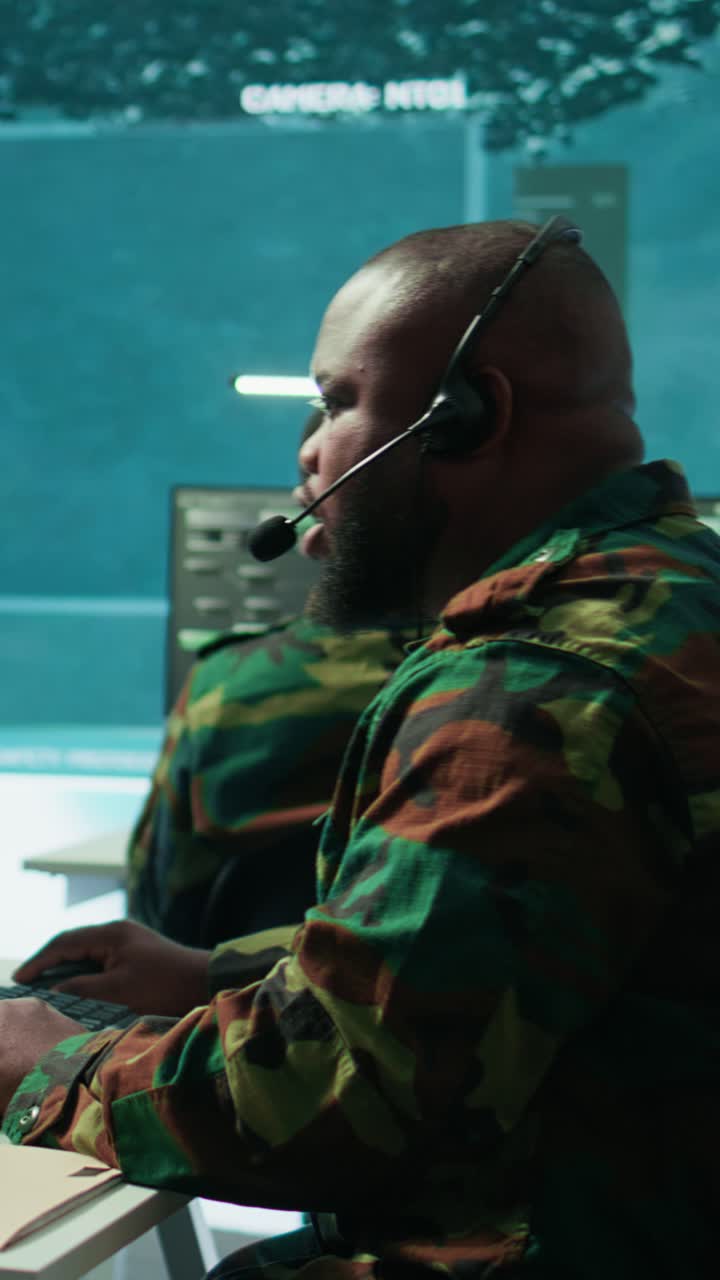 Vertical Video Military personnel in base of operations using advanced computers and big screen