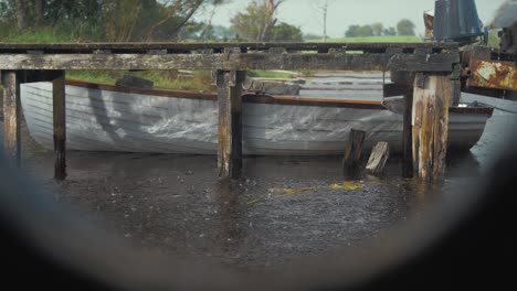 ver a través del ojo de buey ondas de agua de la luz del sol en el lago barco amarrado al aguacero lluvia jetty