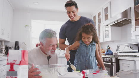 Junges-Hispanisches-Mädchen-Backt-Mit-Großvater-Und-Vater-In-Der-Küche-Und-Füllt-Kuchenformen,-Nahaufnahme