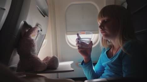 a girl drinks water in the cabin of the plane 4k video